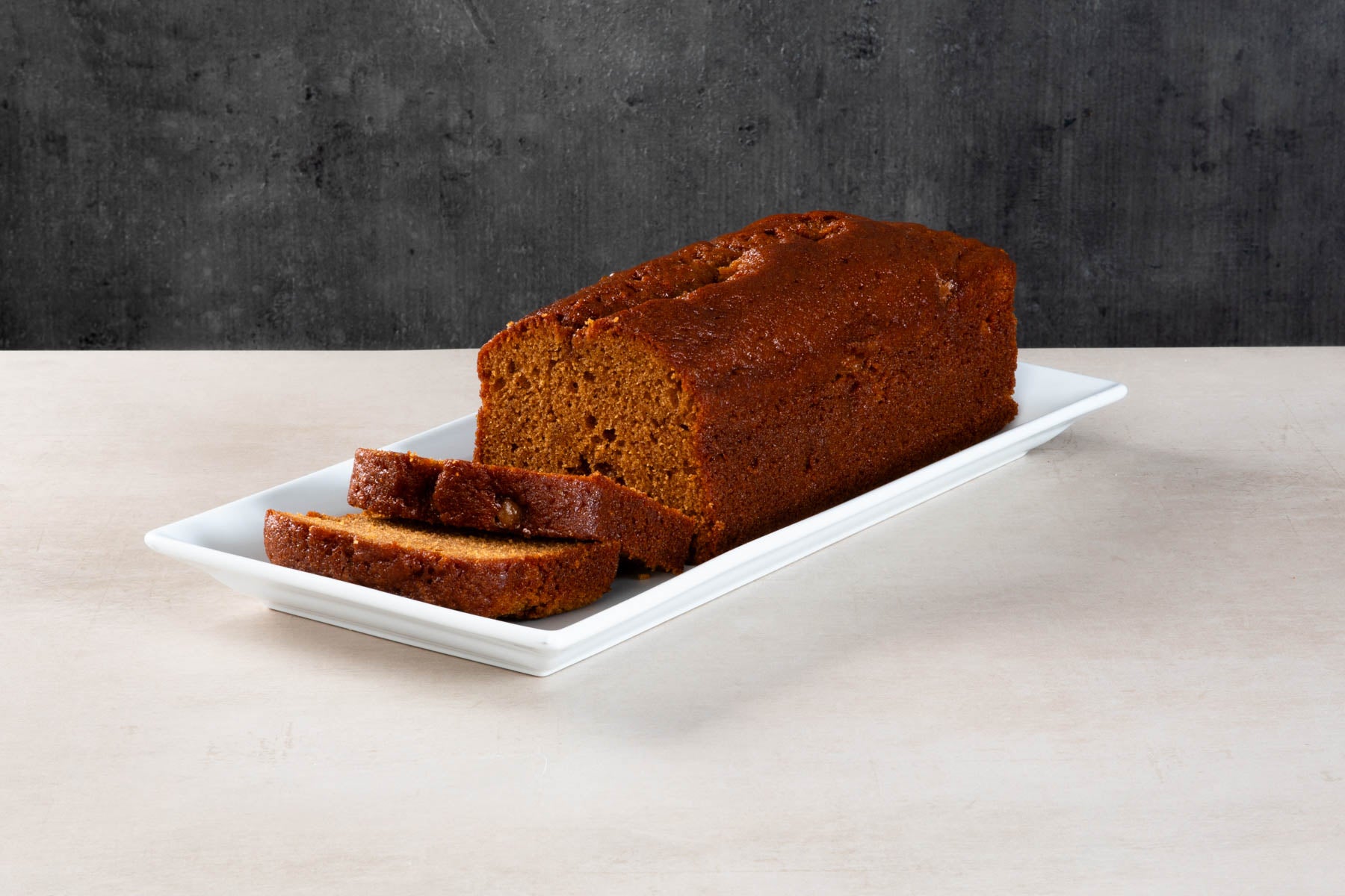 LHMC008-495.jpg Sliced sticky toffee loaf cake on a white platter